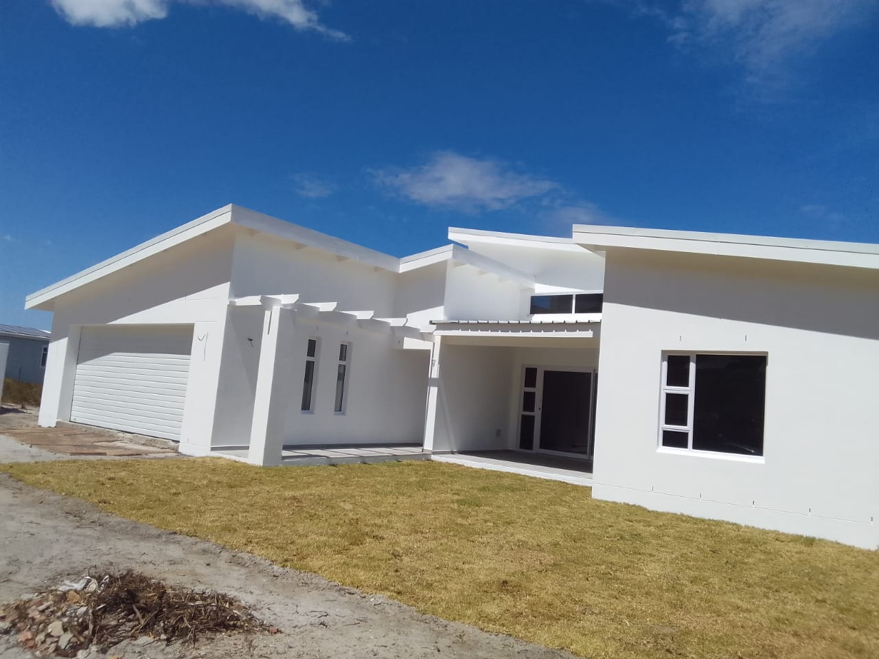 New-build modern home in white with mono-pitch roofs, handed over after painting
